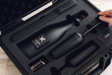 Open COUP Champagne gift set with matte black bottle, flutes, saber, and custom case.