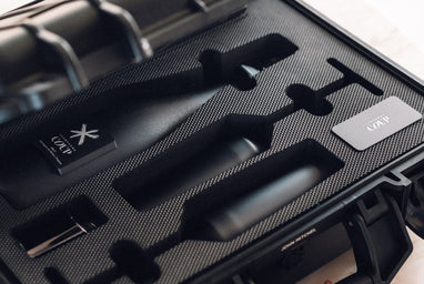  Open COUP gift case with matte black bottle, flutes, saber, and card inside.